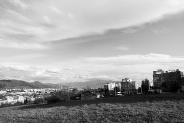 Fototapeta premium Sunrise and sunset, beautiful clouds over the meadow, hills and buildings in the town. Slovakia