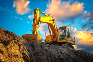 Obraz premium A stopping yellow excavator at an incredibly beautiful sunset