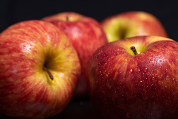 Arrangement with fruits on a shiny black surface with black background.