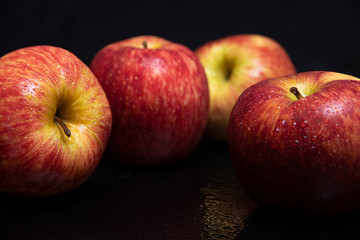 Arrangement with fruits on a shiny black surface with black background.
