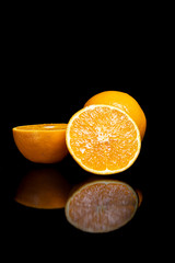 Arrangement with fruits on a shiny black surface with black background.