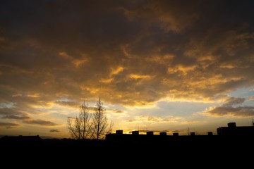 Sunrise and sunset, beautiful clouds over the meadow, hills and buildings in the town. Slovakia