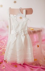 Stock Photo - Child dress on hanger on pink background