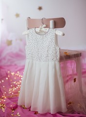 Stock Photo - Child dress on hanger on pink background