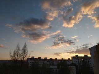 Sunrise and sunset, beautiful clouds over the meadow, hills and buildings in the town. Slovakia