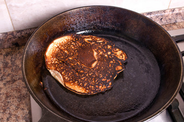 Cooking failed, burnt pancakes on a black pan