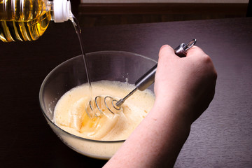 The process of pouring, adding vegetable oil to the dough for the preparation of pancakes