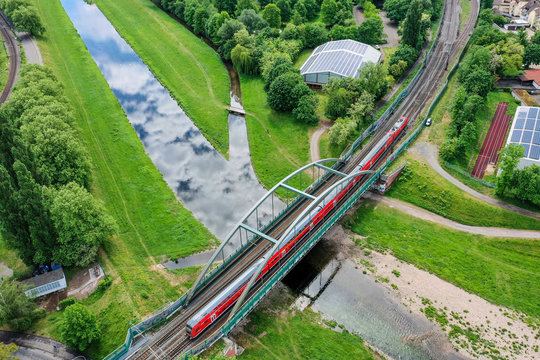 Ein roter Zug überquert die Murg in Rastatt.