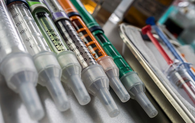 Syringes of insulin medication next to medicine vials prepared in hospital, conceptual image