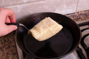 A Closeup shot of a cook turning pancakes on a grill