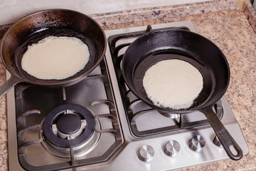 The process of cooking pancakes on a hot skillet