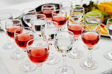 crystal glasses with water and red wine stand on a welcome table with a white tablecloth awaiting guests of the holiday