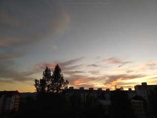 Sunrise and sunset, beautiful clouds over the meadow, hills and buildings in the town. Slovakia