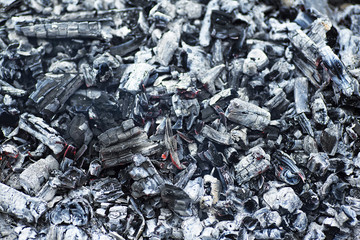 Details of charcoal for barbecue at picnic. Burning coals after grilling. Ash background.