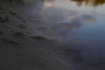 Fototapeta na wymiar Delikatna gra światła na piachu i wodzie.