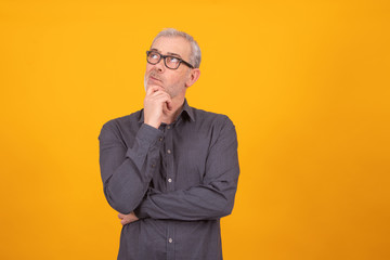 adult or senior man isolated on color background with thoughtful expression