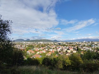 Obraz premium Sunrise and sunset, beautiful clouds over the meadow, hills and buildings in the town. Slovakia