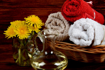 bouquet of dandelion flowers, body oil, and towels with free space for text