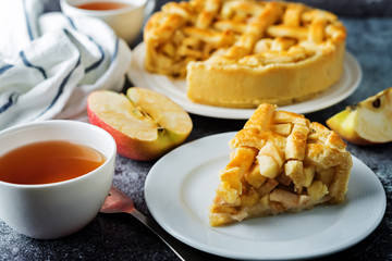 Apple cake with fresh apple slices and cups of tea