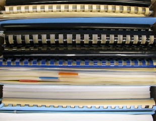 Stack of papers and notebooks with comb binding