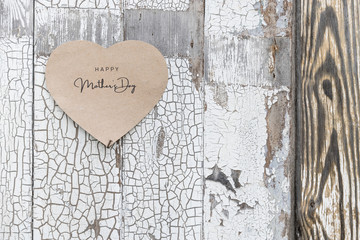 Happy Mother's Day written on a paper card on a rustic old wall, doors