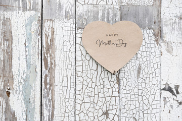 Happy Mother's Day written on a paper card on a rustic old wall, doors