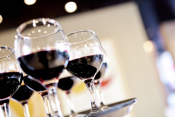 crystal round glasses with red wine stand on a table awaiting guests