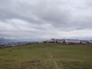 Obraz premium Sunrise and sunset, beautiful clouds over the meadow, hills and buildings in the town. Slovakia