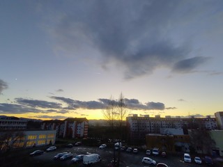 Sunrise and sunset, beautiful clouds over the meadow, hills and buildings in the town. Slovakia