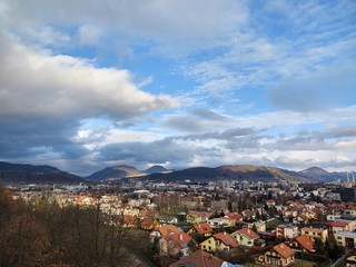 Sunrise and sunset, beautiful clouds over the meadow, hills and buildings in the town. Slovakia