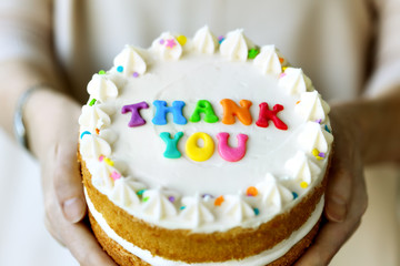 Hands holding thank you cake