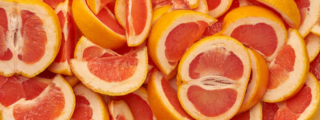 Grapefruit web banner background. Pile of fresh cut grapefruits. Fruits summer bright concept