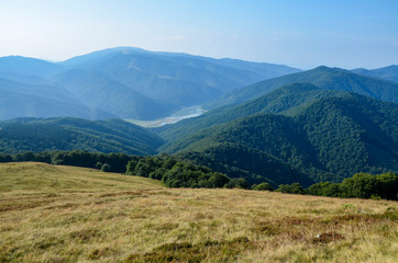 Fototapeta na wymiar Carpathian mountains scenery with hills, water reservoir and blue sky with clouds on the river Tereblya near the Protiven village, Ukraine
