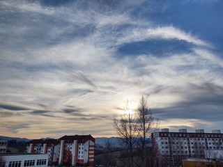 Sunrise and sunset, beautiful clouds over the meadow, hills and buildings in the town. Slovakia