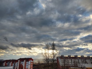 Fototapeta na wymiar Sunrise and sunset, beautiful clouds over the meadow, hills and buildings in the town. Slovakia