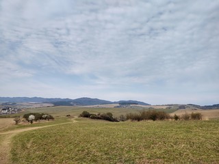 Fototapeta premium Sunrise and sunset, beautiful clouds over the meadow, hills and buildings in the town. Slovakia