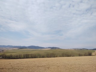 Fototapeta premium Sunrise and sunset, beautiful clouds over the meadow, hills and buildings in the town. Slovakia