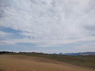 Sunrise and sunset, beautiful clouds over the meadow, hills and buildings in the town. Slovakia