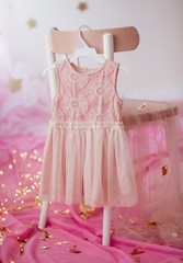 Fototapeta na wymiar Stock Photo - Child dress on hanger on pink background