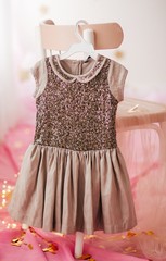 Stock Photo - Child dress on hanger on pink background