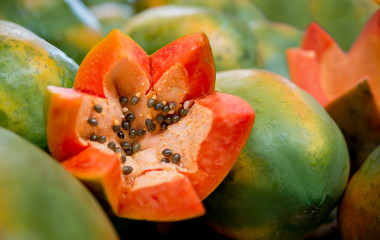 Fresh sliced papaya, zigzag cutted with seeds. Asian fruit, organic nutrition, vegeterian. Healthy food with vitamins. Whole and cutted papaya in asian market