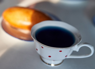 the pie lies on a plate with a cup of tea