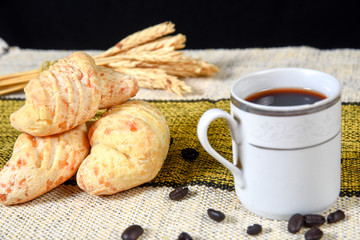 Traditional Brazilian Biscuit with Fresh Cheesebaked cheese biscuit, with cup of coffee, on the table.