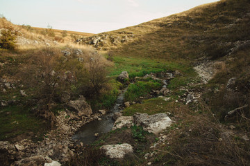 green valley in a rocky gorge with a small stream. northern moldova - natural landscape. countryside landscape. Tourism and travel to Moldova.