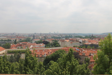 Fototapeta na wymiar urban landscape top view red roofs of houses and visible square and castle Prague Czech Republic