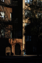 A man wearing a mask with a stroller walking on the street in new york