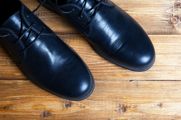 Men's black shoes on a wooden table
