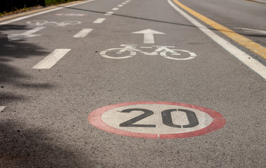 bicycle and speed limit signs on asphalt path