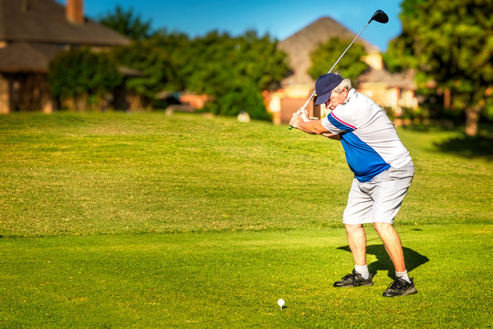 Man Teeing Off In The Tee Box, Playing Golf