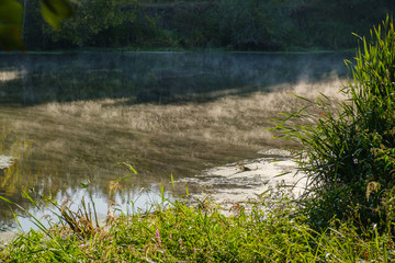 Fototapeta na wymiar Morning fog on a calm river, tranquil scene on river, cold color toned image
